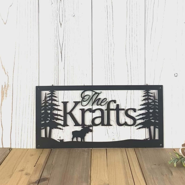 Video of personalized family last name metal sign with moose and trees, in matte black powder coat.