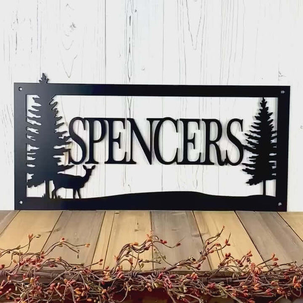 Video of personalized family last name metal sign with doe deer and pine trees, in matte black powder coat.