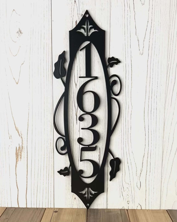 Video of vertical metal house numbe sign with vines and fleur-de-lis, in matte black powder coat.