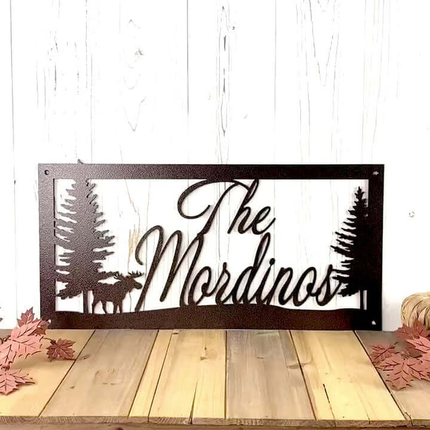 Video of custom cursive family name metal sign with moose and pine trees, in copper vein powder coat.