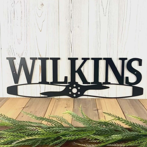 Video of Airplane propeller custom family name sign, in matte black powder coat.