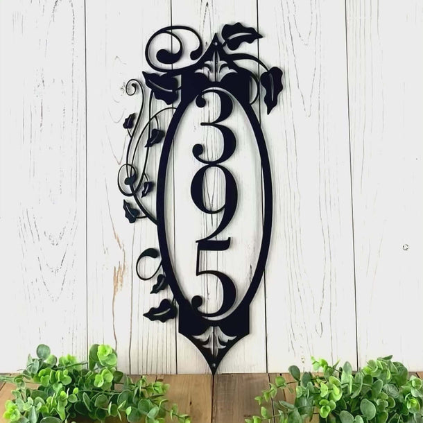 Video of vertical metal house number sign with vines and fleur-de-lis, in matte black powder coat.