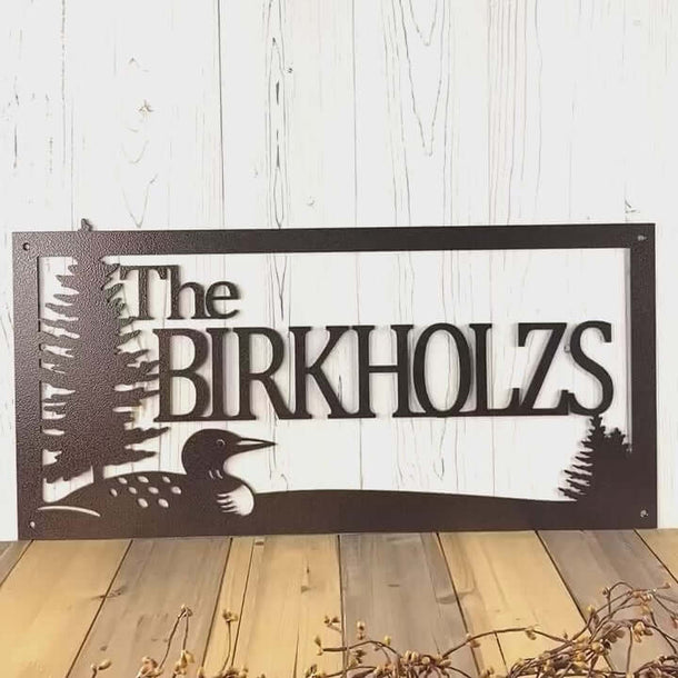 Video of personalized family last name metal sign with lake loon and pine trees, in copper vein powder coat.