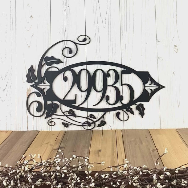 Video of oval 5 digit metal house number sign with vines and fleur-de-lis, in matte black powder coat.