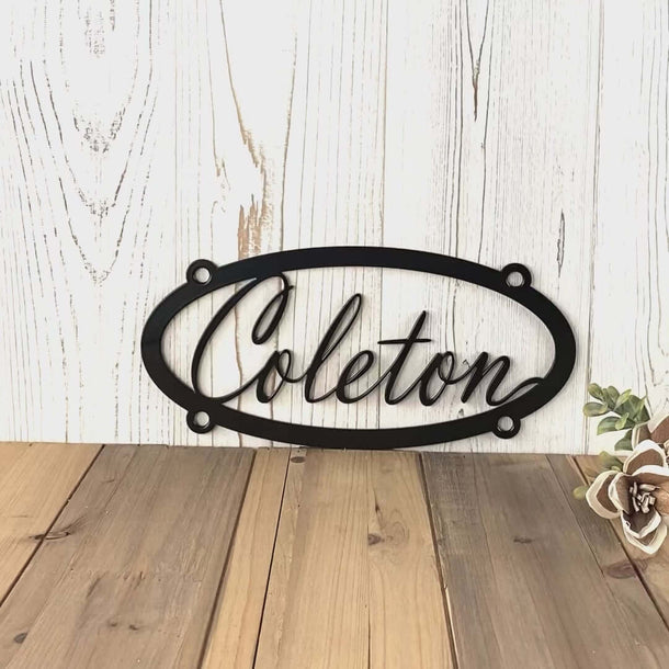 Video of hanging oval personalized name metal sign, in matte black powder coat.