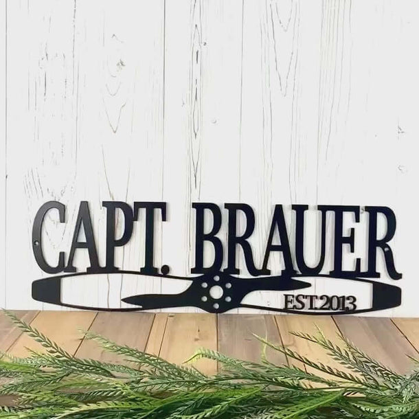 Video of airplane propeller personalized family name and established year metal sign, in matte black powder coat.