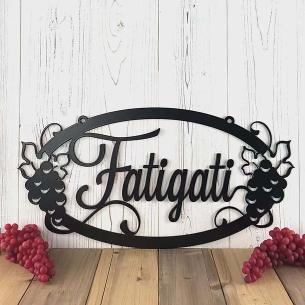 Video of oval personalized family last name metal sign, with grapes and grapevines, in matte black powder coat.
