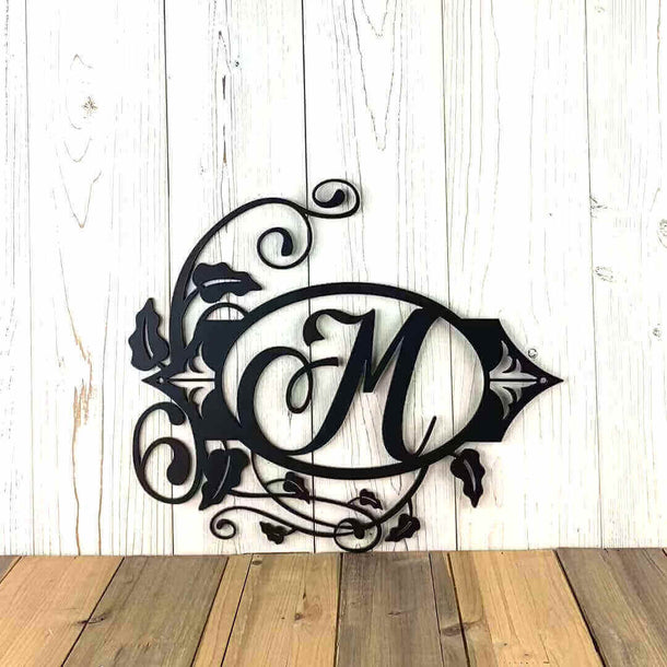 Video of oval metal monogram sign with vines and fleur-de-lis, in matte black powder coat.